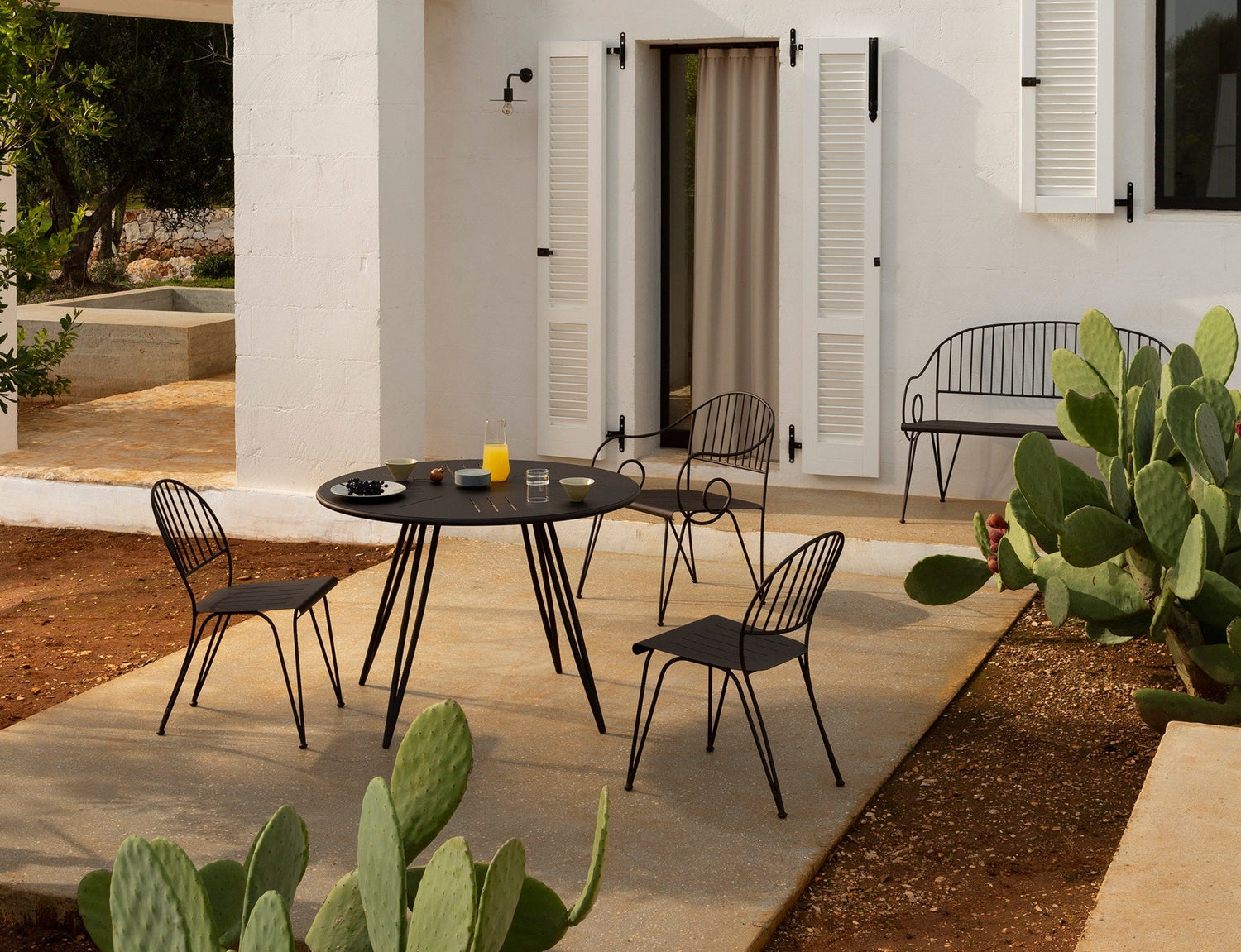 Unopiù Ariete runder Esstisch mit drei Essstühlen und Gartenbank aus pulverbeschichtetem Eisen in Bronze, Outdoor-Dining auf Terrasse, Gesamtansicht