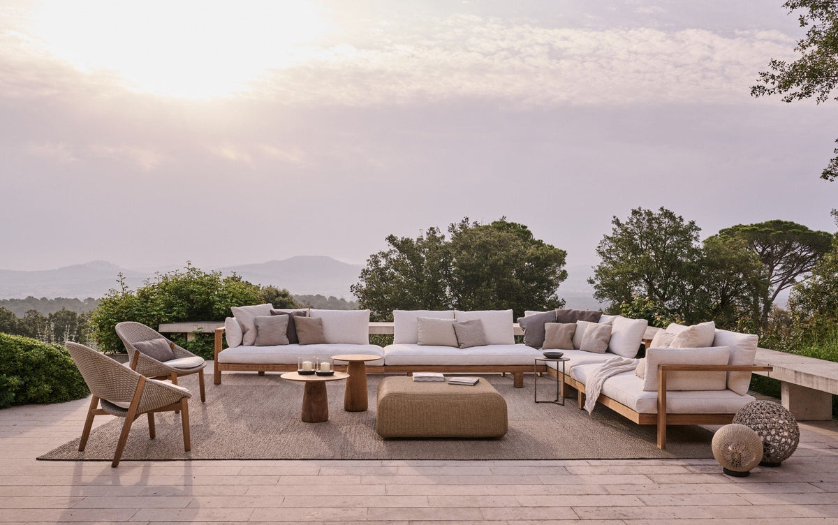 Tribù Pure Loungesofa aus Teak mit hellen Polstern auf einer Terrasse über der Landschaft
