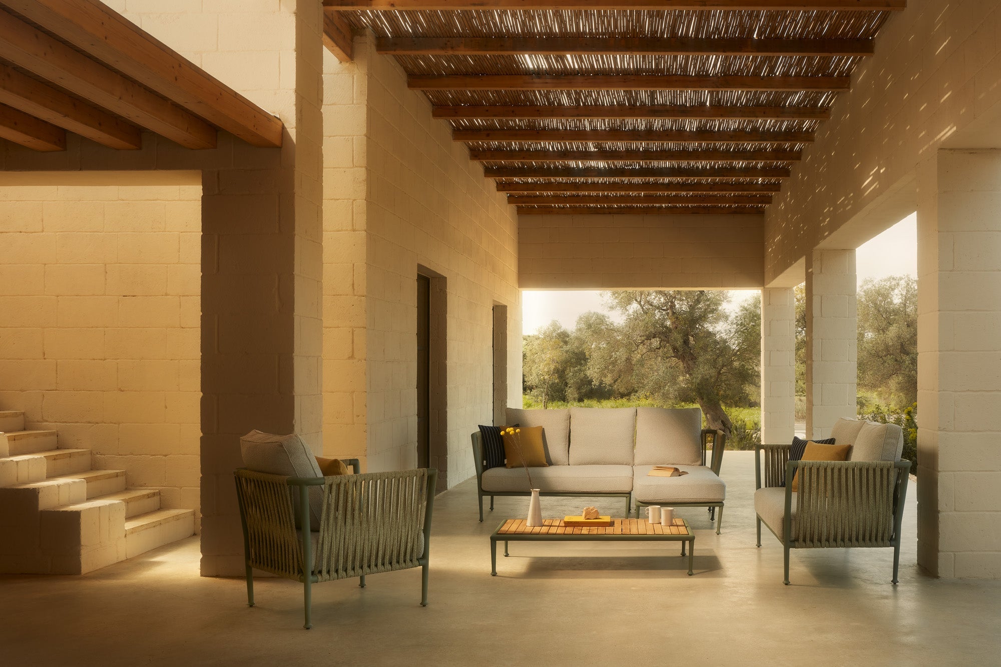 Unopiù Treble modulare Outdoor-Lounge aus Aluminium mit Seilbespannung und Teakholztisch auf moderner Terrasse