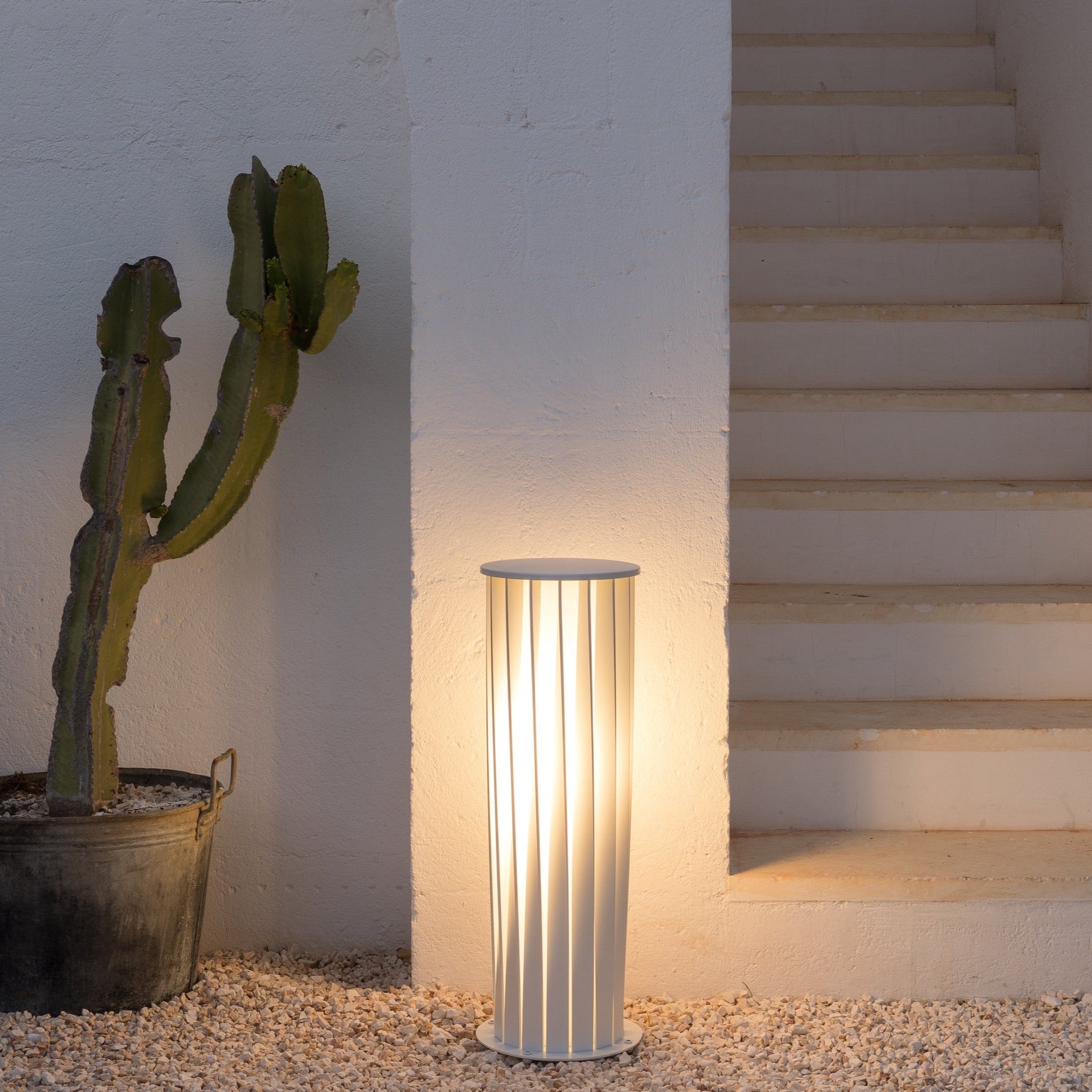 Unopiù Aton Außenleuchte mit gedrehtem Aluminiumschirm in Weiß im Gartenbereich