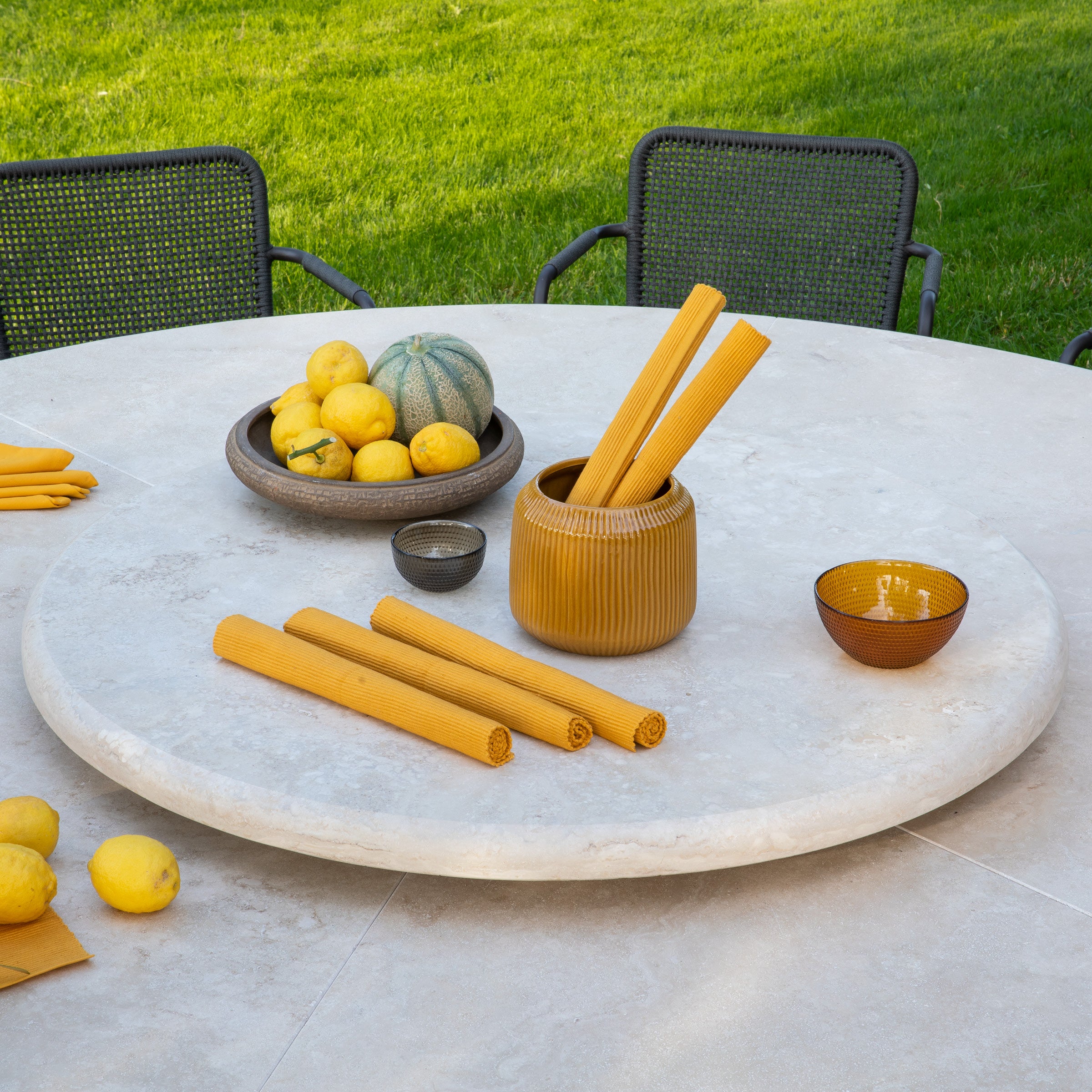 Der HERMU Gartentisch in einem modernen Außenbereich, umgeben von stilvollen Gartenstühlen, die perfekt zur Tischbasis passen.