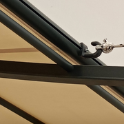 Detailansicht der Unopiù Ersatz-Öse für Federzugrollo an Pergola-Modell Solaire, montiert an einem pulverbeschichteten Aluminiumrahmen.