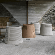 Ein großes, handgefertigtes Pflanzgefäß aus Ton in der Farbe Grau. Es hat eine runde Form und wirkt sehr elegant und modern.