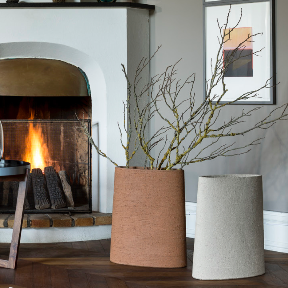 Atelier Vierkant CC50 sind in der Farbe Cork links und rechts in extra weiss zusehen. In den Vasen  stehen Birkenzweige vor einem brennenden Kamin.