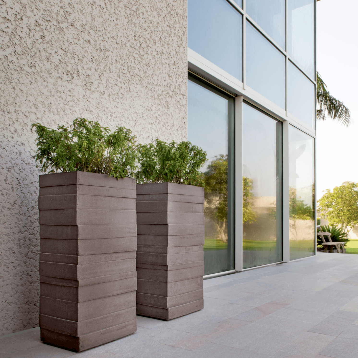 Atelier Vierkant BRL100 Gefäße stehen vor einem modernem Haus auf einer Naturstein Terrasse.