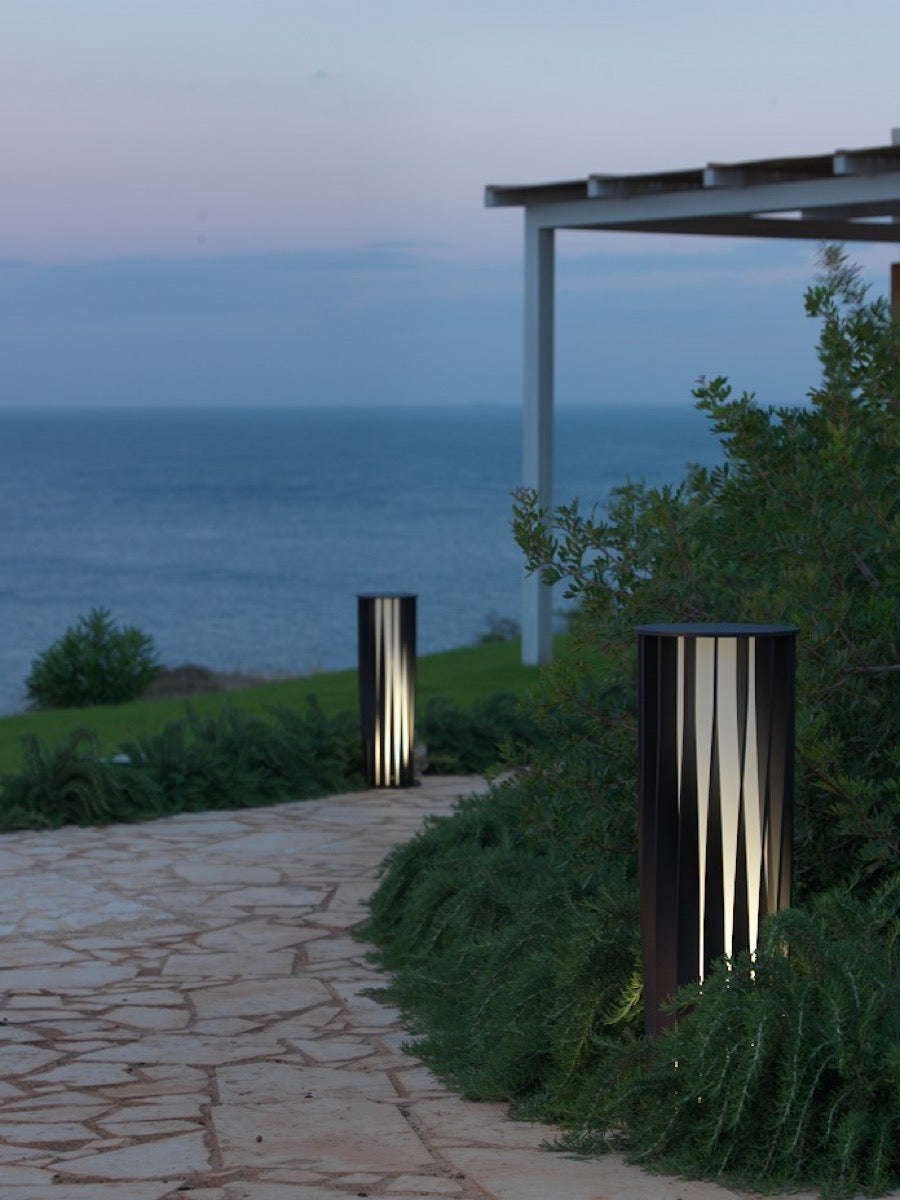 Das faszinierende Design dieser Leuchte zeichnet sich besonders durch die verdrehten Aluminiumlamellen aus, die für einen ganz besonderen Lichteffekt sorgen. Aton ist in Weiß oder Bronze erhältlich.  Die verarbeiteten Materialien eignen sich für den Außenbereich, jedoch auch perfekt für den Innenbereich.  Lampe aus Aluminium mit gedrehten Leisten (Ø 26 - H 150 cm)