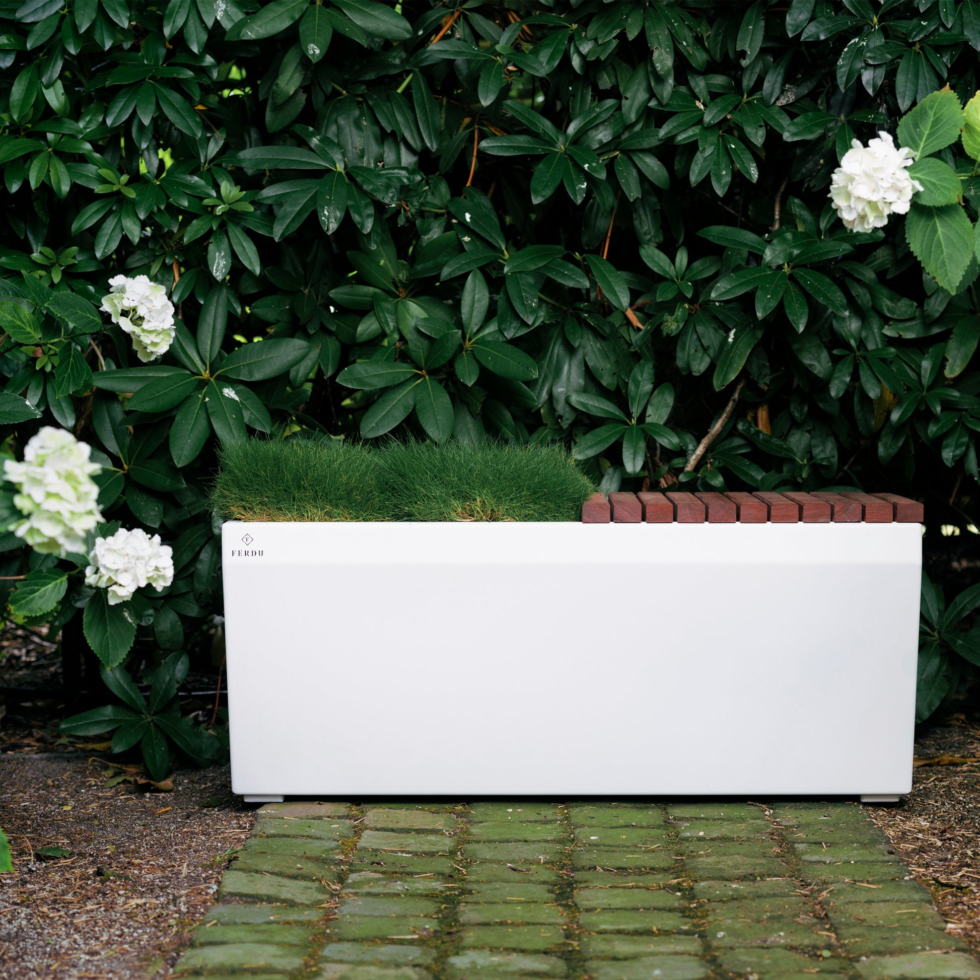 Pflanzengefäß Berta von FERDU von Hand in Belgien gefertigt. Dieses Gefäß ist aus Corten-Stahl. Dieses Blumengefäß ist zur Hälfte mit einer Sitzfläche versehen. Farbe weiss