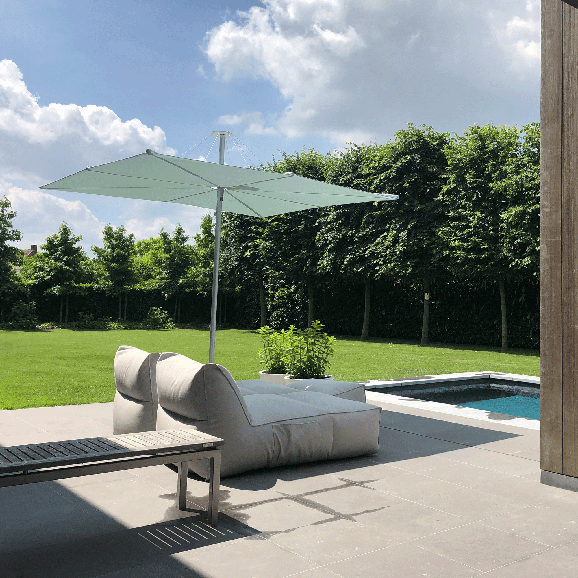 Umbrosa Sonnenschirm Infina 3x3m in weiß auf einer privaten Terrasse im Garten.