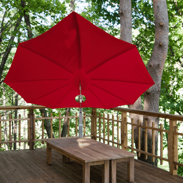 Umbrosa Sonnenschirm Icarus mit roter Bespannung gibt Sonnenschutz für einen Teakholz Esstisch.