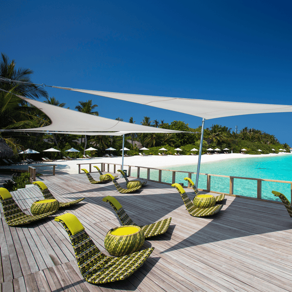 Zwei weise Sonnensegel des Model´s Inngenua von Umprosa dienen als Sonnenschutz auf einer Terrasse in der Karibik.