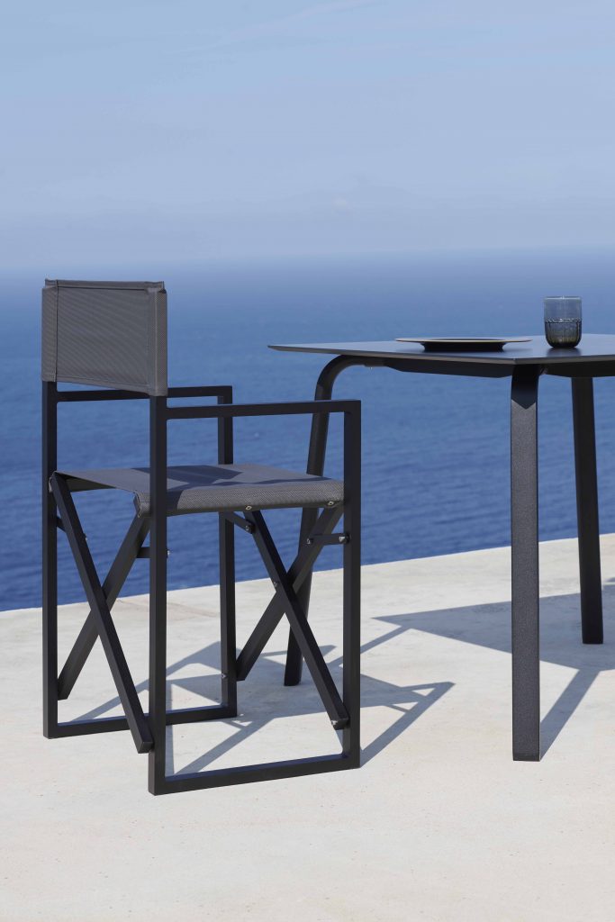 Gandia Blasco Clack! Folding Chair in schwarz, Seitenansicht, am Tisch 