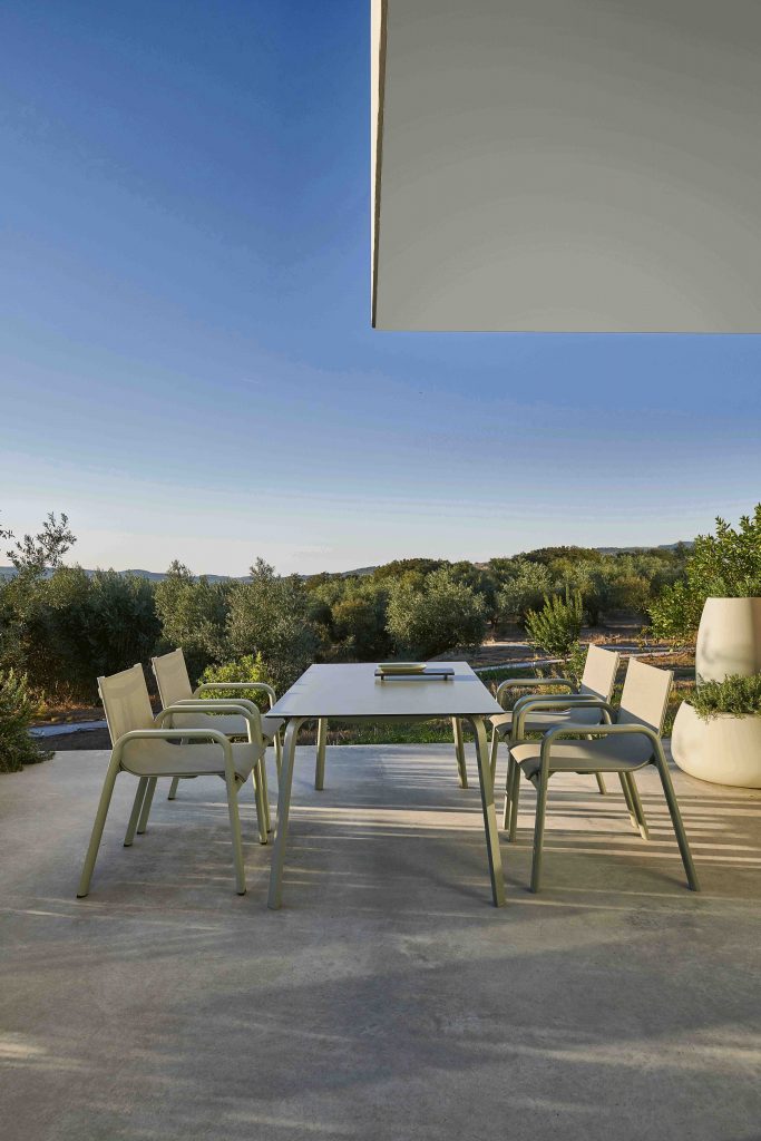 Gandia Blasco Stack Dining Club Armchair in zementgrau, Seitenansicht, am Tisch 
