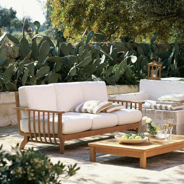 Unopiu Chelsea Sofa mit Chelsea Lounge Tisch aus Teakholz stehen auf einer italienischen Terrasse mit Naturstein.